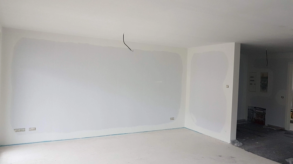 Pusty pokój z nałożonymi gładziami na ścianach i suficie